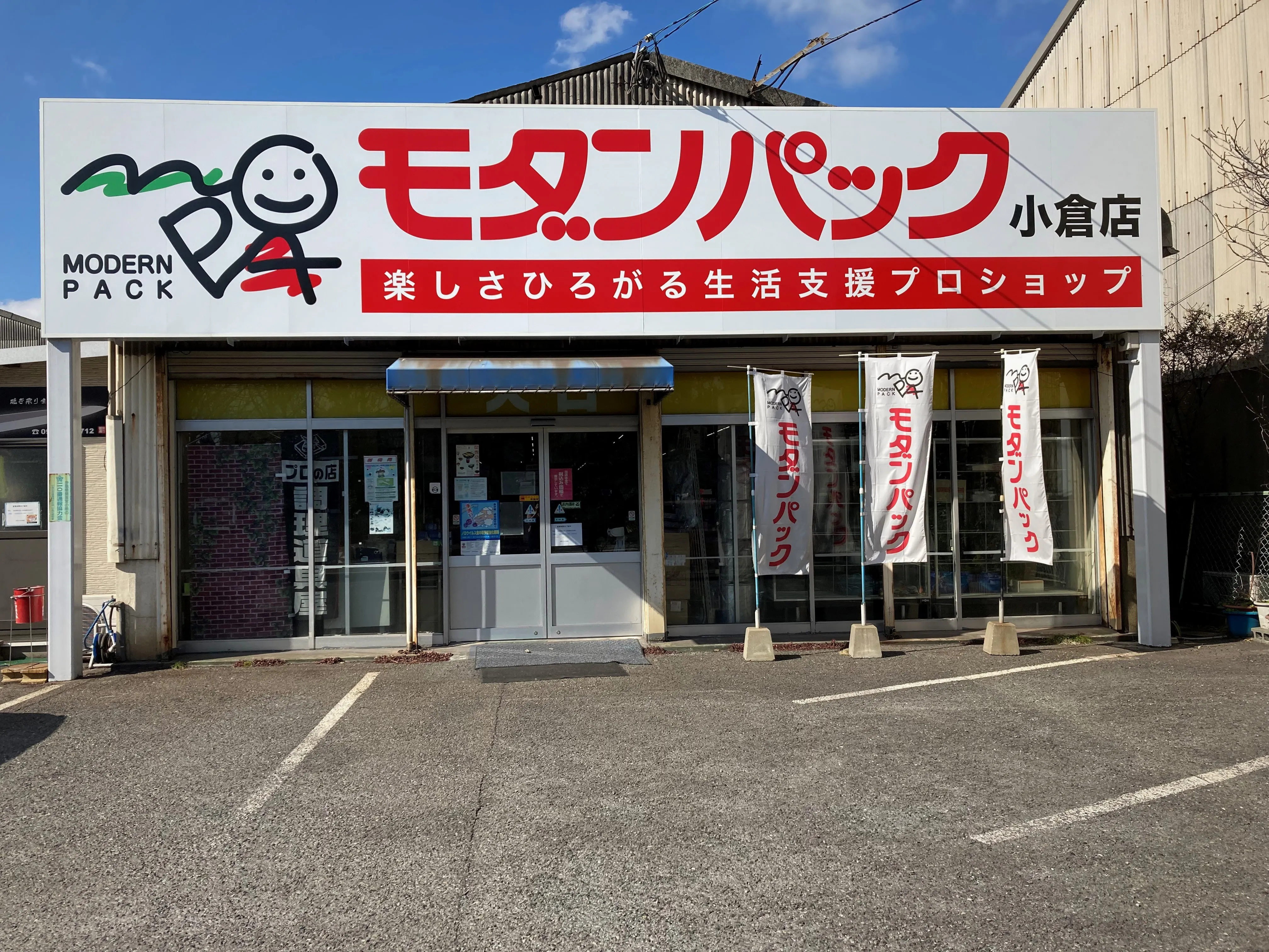モダンパック・小倉店の正面。看板と入口、店の前の駐車場